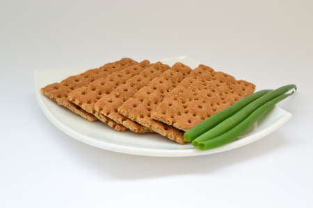 Dietary bread with green onion on white plateの写真素材