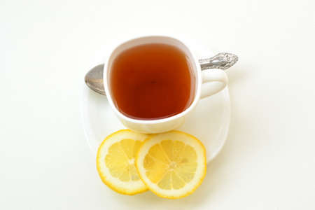 Cup of tea with lemon slices on a white plate