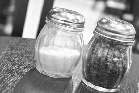 Chili flakes and shreaded cheese in containers in grey scale toneの写真素材