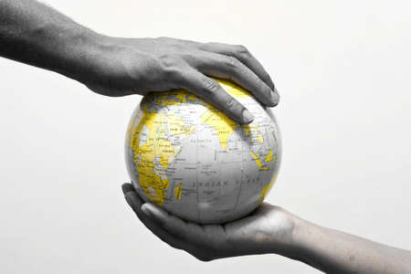 two hands on  globe, a conceptual picture showing the earth being protected and conserved with only the continents highlightedの写真素材