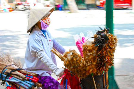 Ho Chi Minh City, Vietnam - June 10, 2010 -  A Vietnamese broom and duster stall owner transporting her products. のeditorial素材