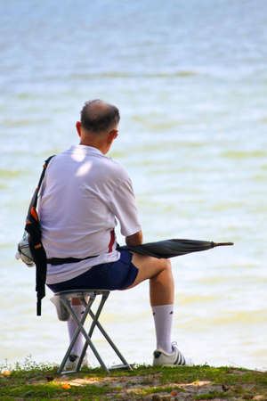 East Coast Park, Singapore - August 10, 2010 - A retired elderly sitting all alone by the beach in deep thoughts. のeditorial素材