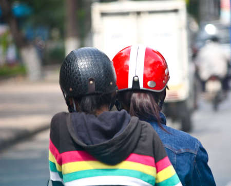 Ho Chi Minh City, Vietnam - June 10, 2010 - Vietnamese rider and her pillion wearing safety helmets while riding on the roads of Ho Chi Minh City, it is a saftey regulation that needs to be adhered.のeditorial素材