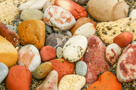 Closeup of many little stones on the coast of black seaの写真素材