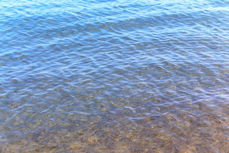 Blue clear water. Sea, lake, sun, beach, vacation Background for inserting images and text. Tourism, travel.の写真素材