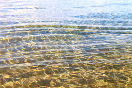 Blue clear water. Sea, lake, sun, beach, vacation Background for inserting images and text. Tourism, travel.の写真素材