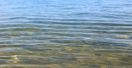 Blue clear water. Sea, lake, sun, beach, vacation Background for inserting images and text. Tourism, travel.の写真素材