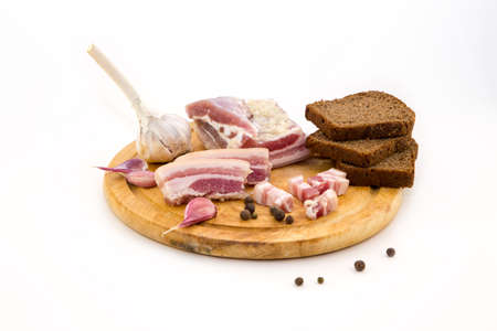 National Russian and Ukrainian food is salo. Sliced bacon on a wooden board. On a white background.の写真素材
