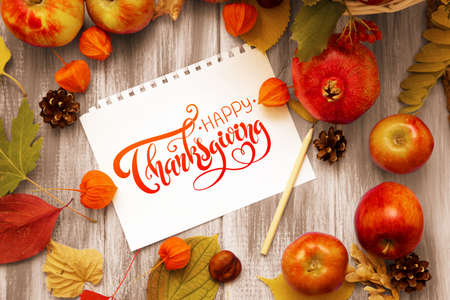 Thanksgiving - letters. Autumn bright background. Flowers, leaves and fruits on a blue wooden background. Background for the autumn holidays and thanksgiving day.