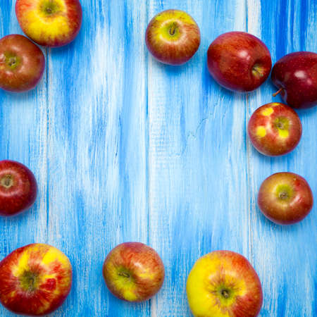 Apples on a blue wooden background. Red and yellow farm apples.の写真素材