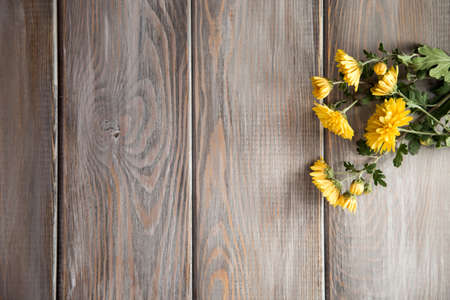 Autumn background. Flowers on a brown wood background. Place for inscription. Background for autumn holidays and thanksgiving day.の写真素材