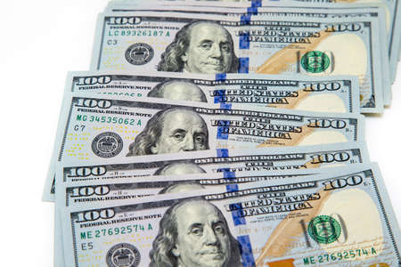 A bundle of hundred dollar bills laid out like a fan. On a white background. Background of dollar...