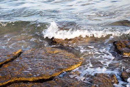 Beautiful coastline with stones and water. blue sea wave photograph close up. vacation at sea or...