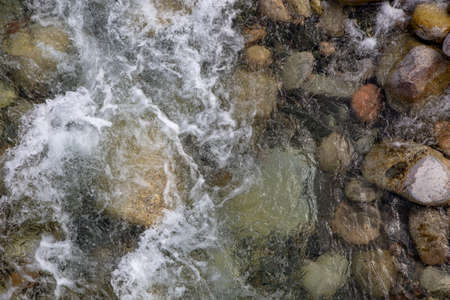 Water in the mountain raging river. Beautiful natural background of stones and water. Texture of...
