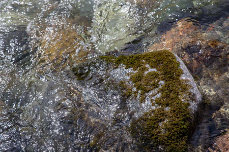 Water in the mountain raging river. Beautiful natural background of stones and water. Texture of...