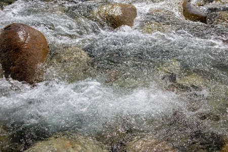 Water in the mountain raging river. Beautiful natural background of stones and water. Texture of...