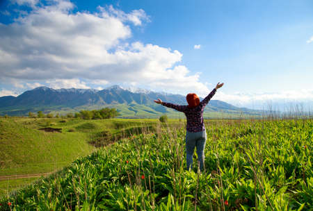 Girl on the nature with joy looks at the mountains. Beautiful summer landscape. High mountains,...