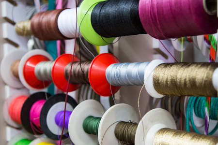 multicolored threads and ribbons. Background for the store selling reels with ribbons. materials for sewing and creativity. Fashionable craft of women.の写真素材
