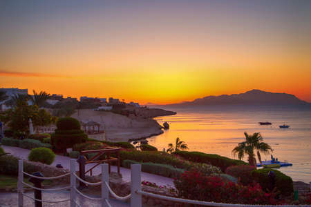 Sunrise over the red sea. Beautiful bright sky with sun rays and morning clouds. Sea and boats. View of Tiran Island. Egypt, Sharm El Sheikh. Tourism and travel. Rest and vacation.の写真素材