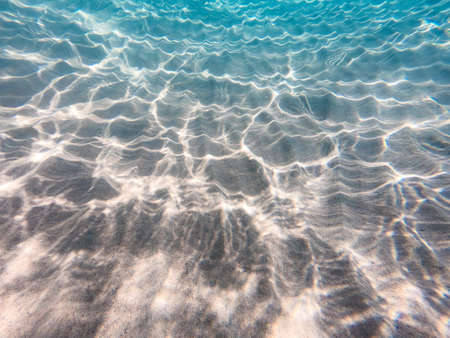 underwater background with sandy sea bottom. Beautiful texture of the sea and ocean water.の写真素材