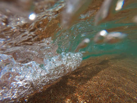 The texture of clear water with sandy bottom. Natural natural background.