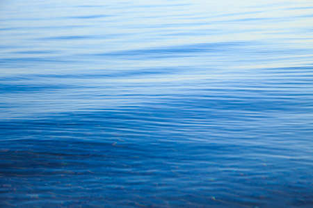 Clear water texture in blue and orange. Background of the ocean and the sea backlit by the sun. Natural waterの写真素材