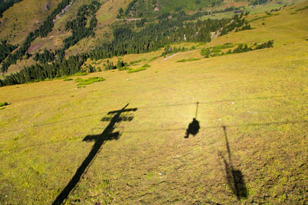 Summer mountain landscape high in the mountains. Tall trees of Christmas trees, ski lift at the ski baseの写真素材