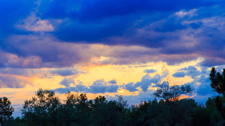 Bright cumulus clouds against the blue sky. Sunset sky Natural background.