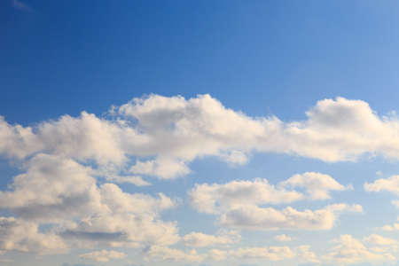Bright cumulus clouds against the blue sky. Sunset sky Natural background.の写真素材