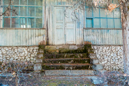 Old abandoned building. Against the backdrop of winter mountains. Gloomy landscape.の写真素材