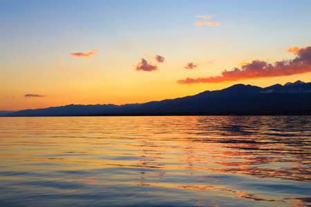 Beautiful cloudy sunset over the sea and mountains. Bright sky in the rays of the orange sun. naturalの写真素材