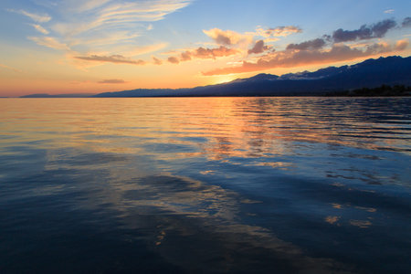 Beautiful cloudy sunset over the sea and mountains. Bright sky in the rays of the orange sun. naturalの写真素材