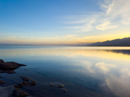 Quiet mountain lake, evening light on the water, Kyrgyzstan. Still water and mountain reflection in the lakeの写真素材