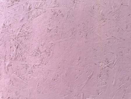 Pink paint cracks on wood surface. texture of painted pressed wood.の写真素材