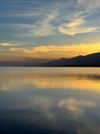 Quiet mountain lake, evening light on the water, Kyrgyzstan. Still water and mountain reflection in...