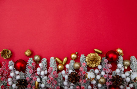 Christmas festive composition with pine cones, baubles and fir branches on red background with copy space. Holiday backdrop for greetings and designの写真素材