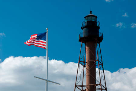 American flag waves by Marblehead lighthouse in Massachusetts.の写真素材