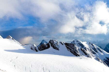mountain peaks with glacier against a blue skyの写真素材