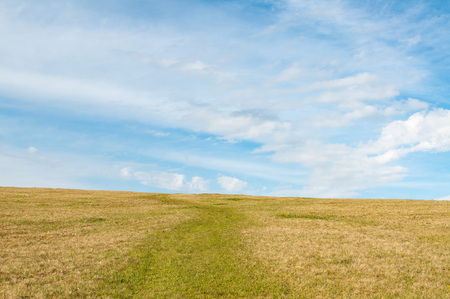 Landscape road crosses the hill against the skyの写真素材