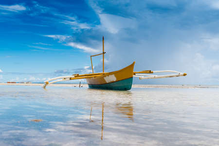 seashore low tide with old boat front view cloudy dayの写真素材
