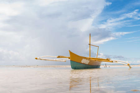 seashore low tide with old boat front view cloudy dayの写真素材