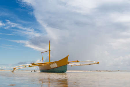 seashore low tide with old boat front view cloudy dayの写真素材