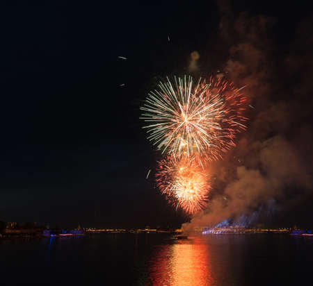night city celebration holiday bright firework above river long exposure shootの写真素材