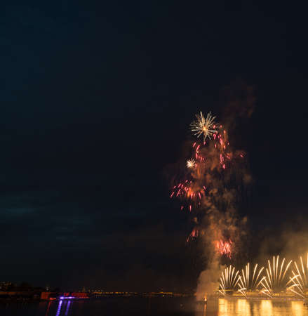 night city celebration holiday bright firework above river long exposure shootの写真素材