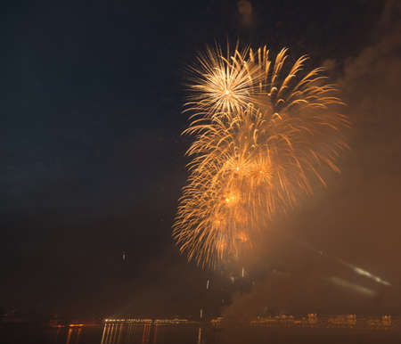 night city celebration holiday bright firework above river long exposure shootの写真素材