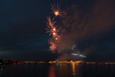 night city celebration holiday bright firework above river long exposure shootの写真素材