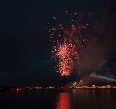 night city celebration holiday bright firework above river long exposure shootの写真素材