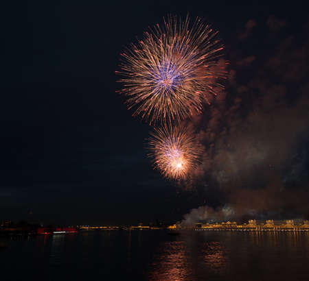 night city celebration holiday bright firework above river long exposure shootの写真素材