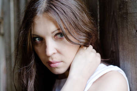 close-up of beautiful woman against a old wooden wallの写真素材