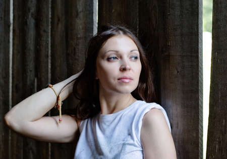 close-up of beautiful woman against a old wooden wallの写真素材